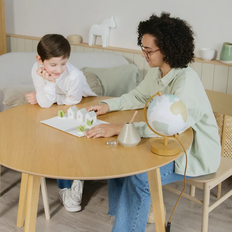 A parent and child working on a geography project at a table